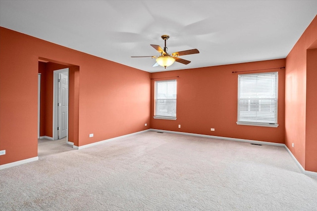 unfurnished room featuring ceiling fan, baseboards, and light colored carpet