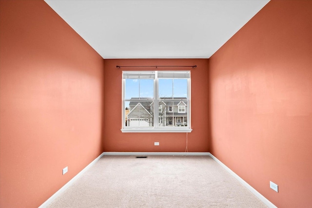 carpeted spare room with visible vents and baseboards