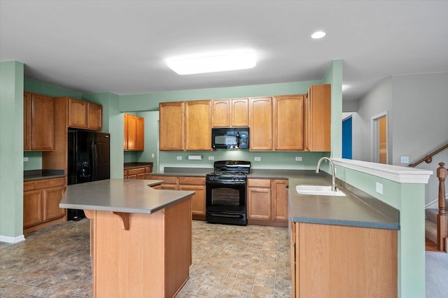 kitchen featuring a breakfast bar, stone finish floor, a kitchen island, a sink, and black appliances