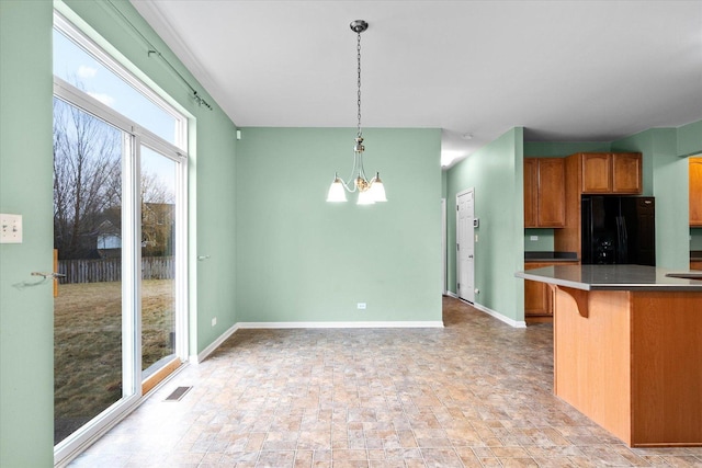 kitchen with freestanding refrigerator, visible vents, baseboards, and an inviting chandelier