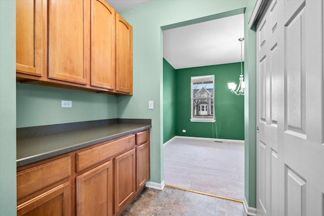 washroom featuring stone finish flooring, a notable chandelier, and baseboards