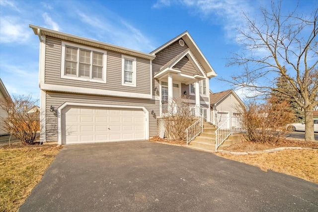 split foyer home with driveway, an attached garage, and a porch