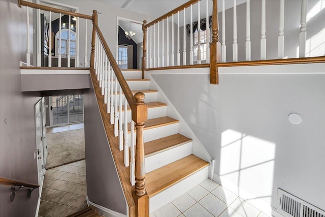 staircase featuring tile patterned flooring, visible vents, and an inviting chandelier