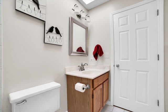 half bath with tile patterned flooring, vanity, toilet, and a skylight