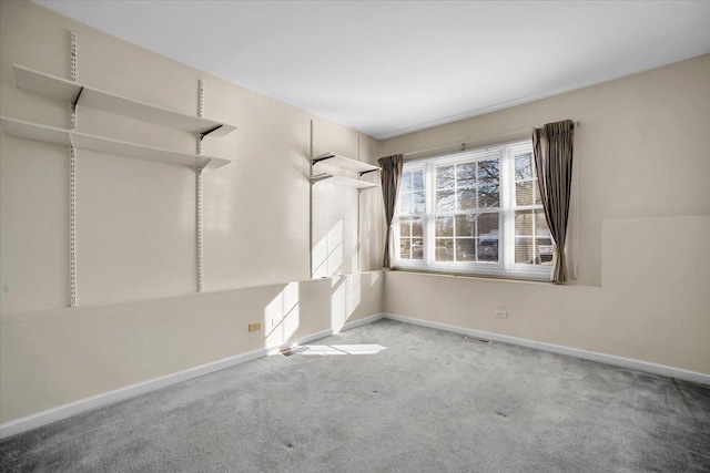 carpeted empty room with visible vents and baseboards