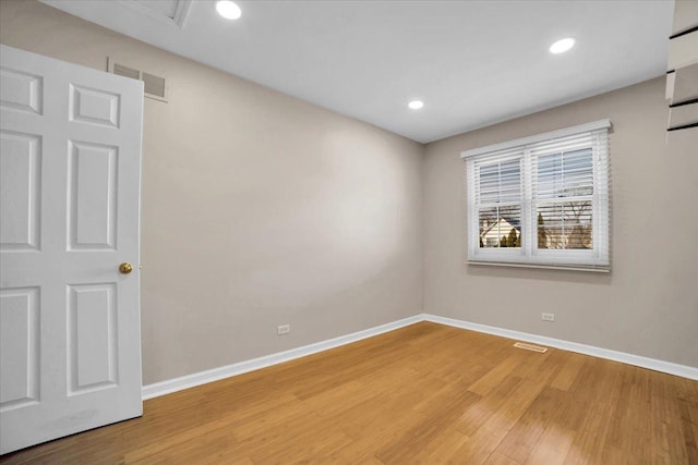 spare room featuring baseboards, visible vents, and light wood finished floors