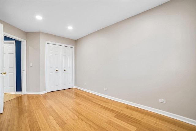 unfurnished bedroom featuring light wood-style floors, baseboards, a closet, and recessed lighting