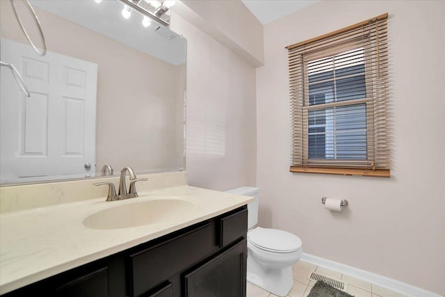 bathroom with baseboards, vanity, toilet, and tile patterned floors