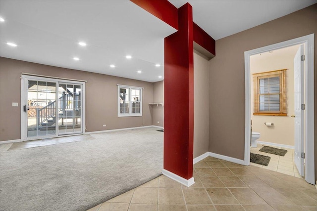 interior space with a wealth of natural light, light colored carpet, and light tile patterned floors