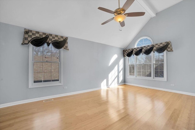 empty room with baseboards, visible vents, ceiling fan, wood finished floors, and beam ceiling