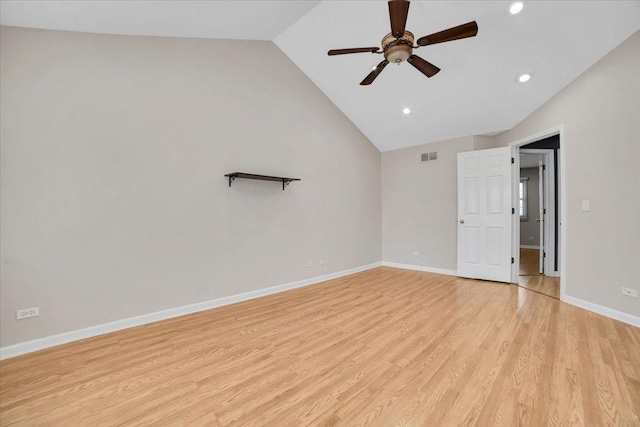 empty room featuring lofted ceiling, visible vents, light wood-style flooring, and baseboards