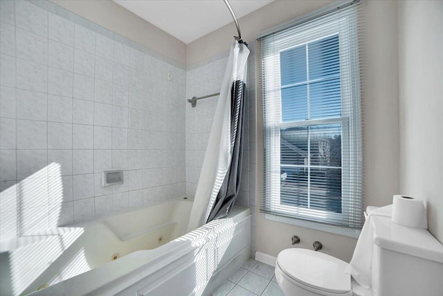 bathroom featuring toilet, tile patterned flooring, baseboards, and a combined bath / shower with jetted tub