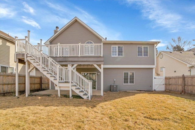 back of property with a lawn, a gate, a fenced backyard, a wooden deck, and stairs