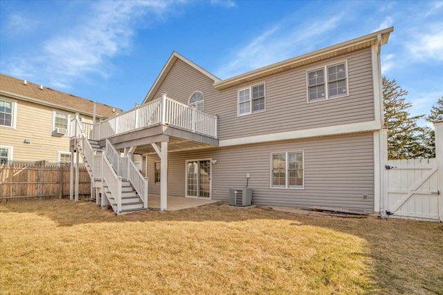 rear view of property with a wooden deck, stairs, fence, and a yard