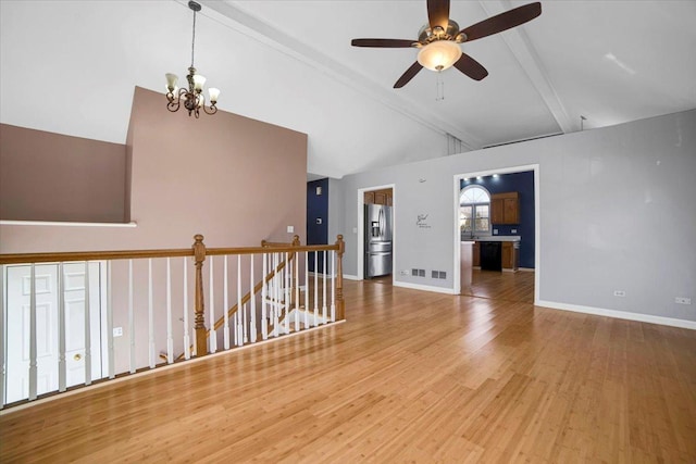 empty room featuring lofted ceiling with beams, baseboards, and wood finished floors