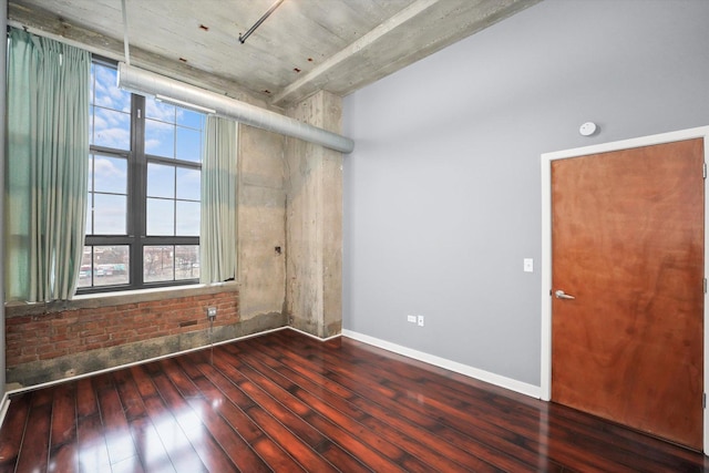 spare room featuring baseboards and hardwood / wood-style floors