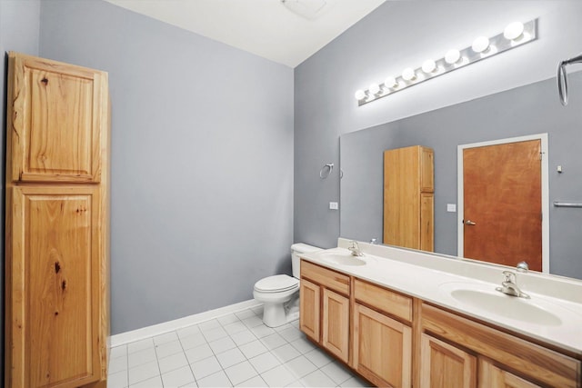 full bathroom featuring toilet, tile patterned flooring, double vanity, and a sink