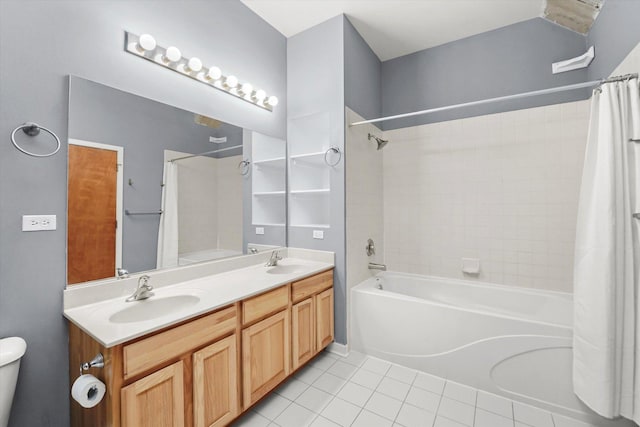 full bathroom with shower / bath combo with shower curtain, a sink, toilet, and tile patterned floors