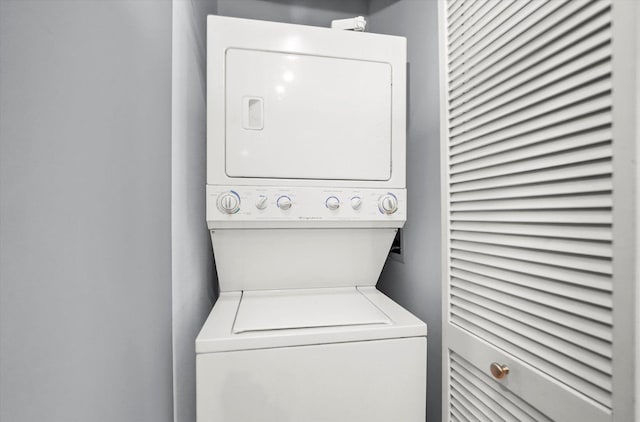 laundry area with stacked washer / drying machine and laundry area