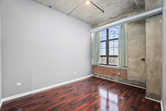 unfurnished room with baseboards and wood finished floors