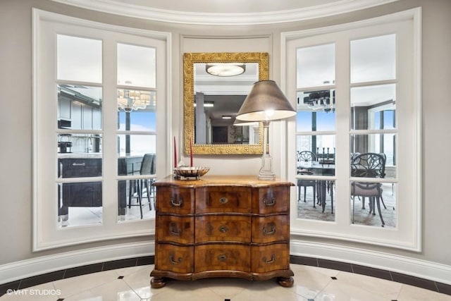 doorway to outside featuring crown molding, a healthy amount of sunlight, and tile patterned floors