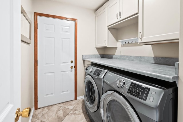 laundry area with light tile patterned flooring, washing machine and dryer, and cabinet space