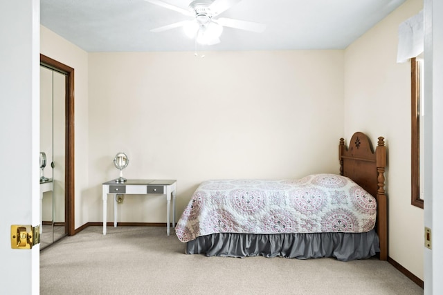 carpeted bedroom with a closet, baseboards, and a ceiling fan