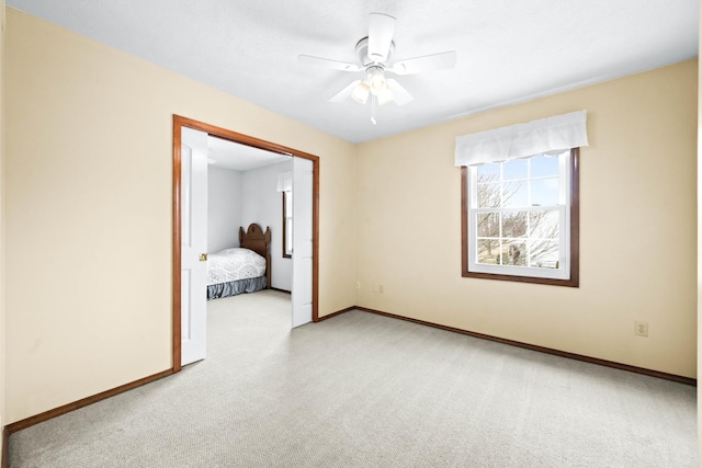 unfurnished bedroom with ceiling fan, baseboards, and light colored carpet