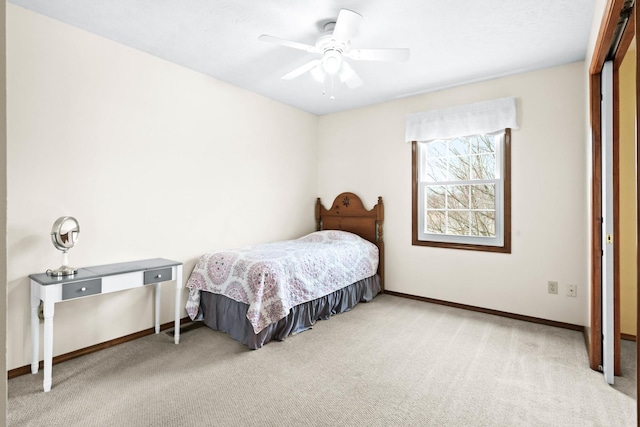 carpeted bedroom with ceiling fan and baseboards