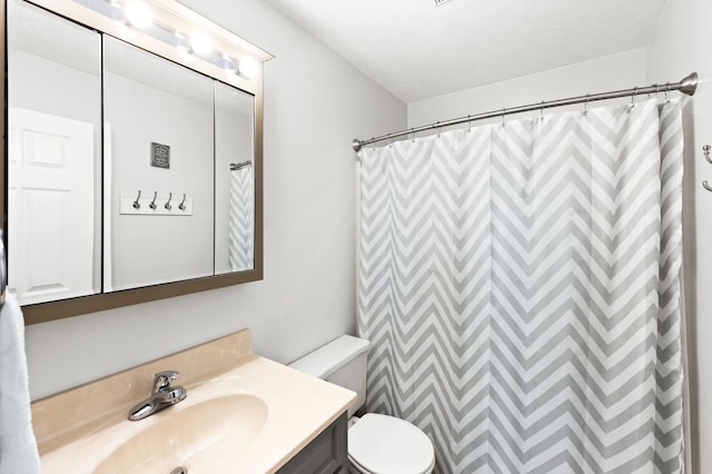 bathroom with toilet, a textured ceiling, and vanity