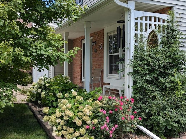 exterior space with covered porch and brick siding