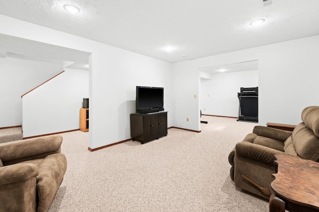 living area with a textured ceiling, carpet flooring, and baseboards