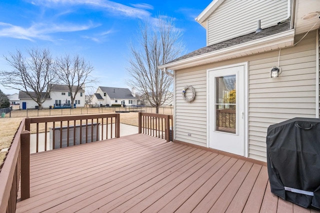 wooden terrace with a residential view, a fenced backyard, and a grill