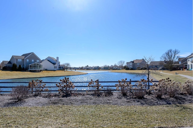 exterior space with a water view and fence