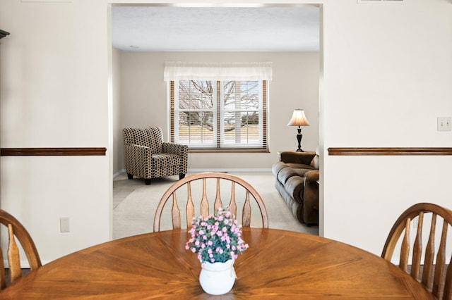 carpeted dining area with visible vents and baseboards