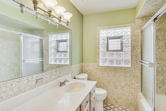 full bathroom with vanity, enclosed tub / shower combo, tile walls, toilet, and a chandelier