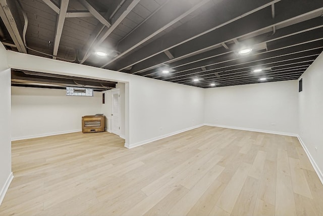 finished basement featuring wood finished floors and baseboards