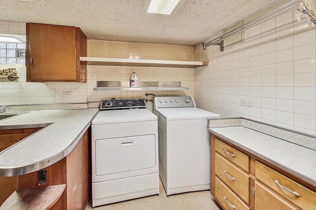 laundry room featuring cabinet space, independent washer and dryer, and a textured ceiling