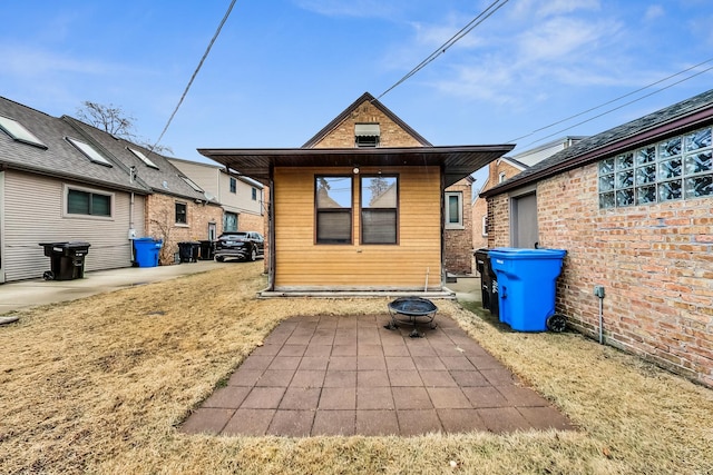 rear view of property featuring a patio area and an outdoor fire pit