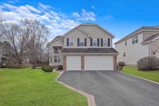 view of front of house with brick siding, a front yard, fence, a garage, and driveway