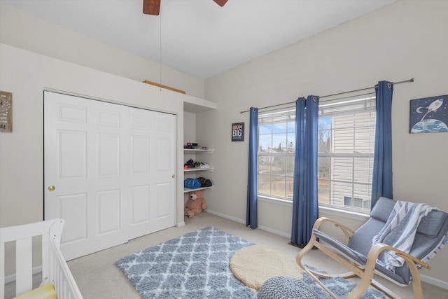 carpeted bedroom with ceiling fan, a closet, and baseboards