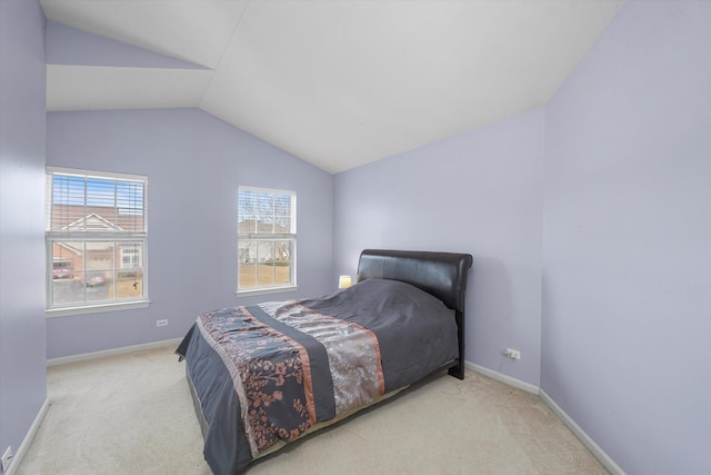 carpeted bedroom featuring lofted ceiling and baseboards