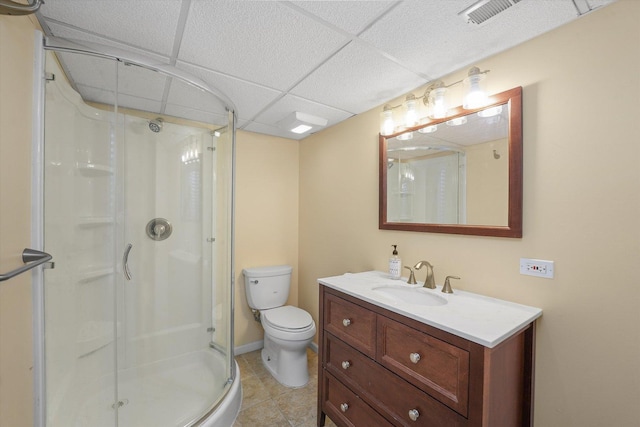 full bath featuring a stall shower, visible vents, toilet, vanity, and a paneled ceiling