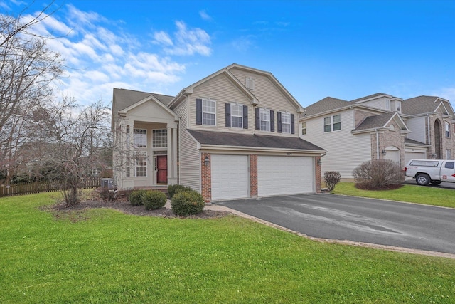 traditional-style house featuring a front yard, brick siding, driveway, and an attached garage