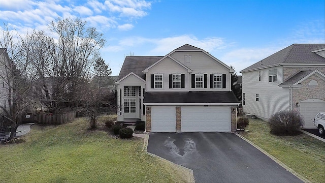 traditional-style home featuring a front yard, brick siding, driveway, and an attached garage