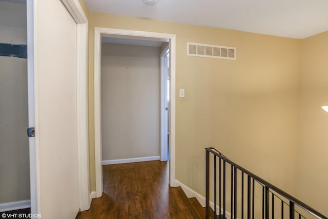 hallway featuring wood finished floors, visible vents, and baseboards