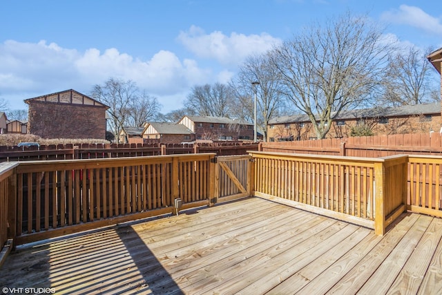 wooden deck with a residential view and a fenced backyard