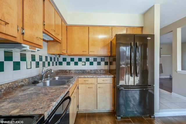 kitchen with tasteful backsplash, dark countertops, baseboards, black appliances, and a sink