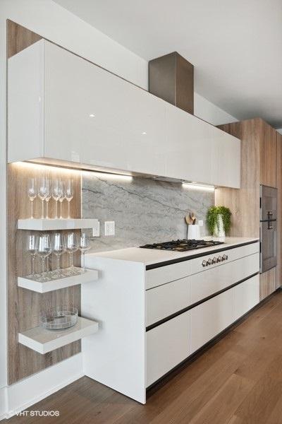 kitchen featuring dark wood-style floors, gas stovetop, light countertops, and backsplash