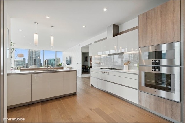 kitchen with backsplash, modern cabinets, a sink, and a city view